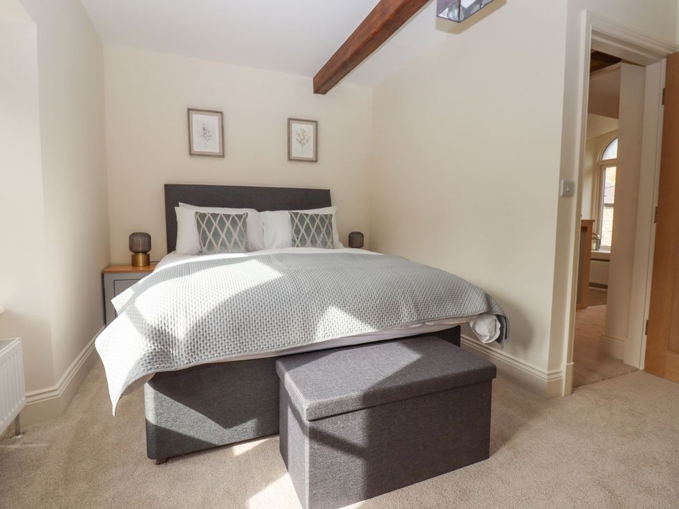 A bedroom with a bed and furniture at 1 Grosvenor Farm Cottages in Skipton