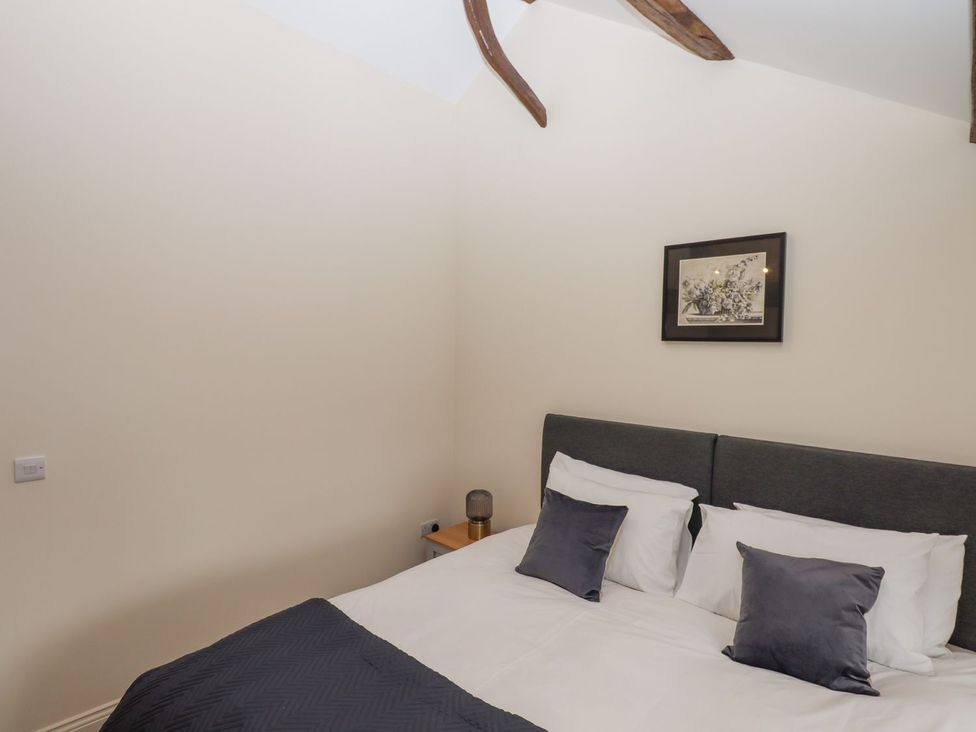 A bedroom with a bed and pillows at 1 Grosvenor Farm Cottages in Skipton