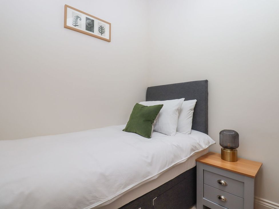A bedroom with a single bed and a nightstand at 1 Grosvenor Farm Cottages, Skipton