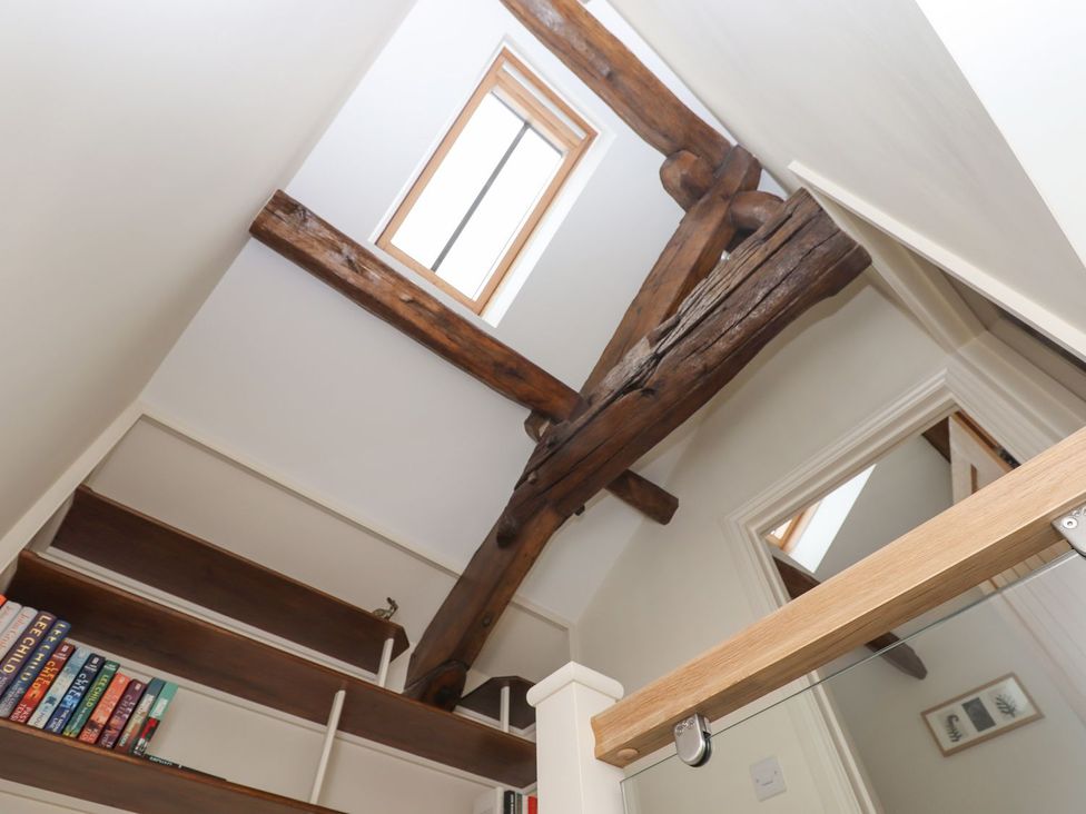 A staircase with wooden beams and a window at 1 Grosvenor Farm Cottages, Skipton