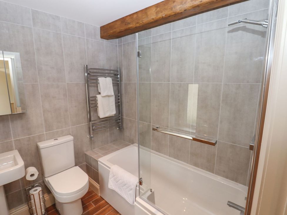 A bathroom with a toilet, sink, shower, and bathtub at 1 Grosvenor Farm Cottages in Skipton