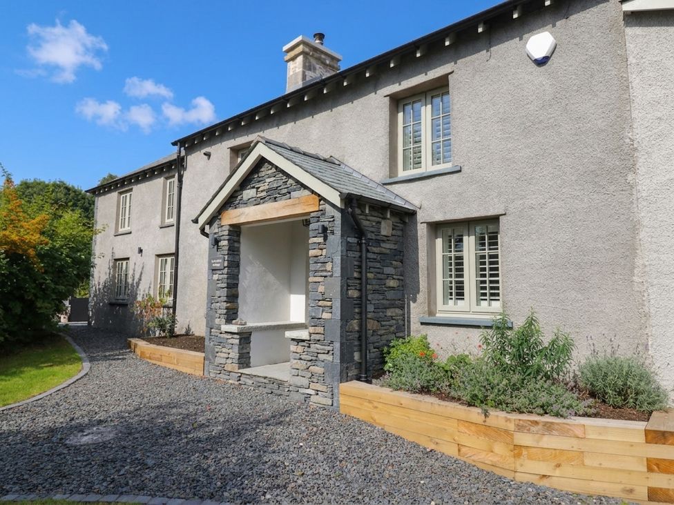 An exterior view of a house with a stone feature at Low House Cottage Ayside near Newby Bridge