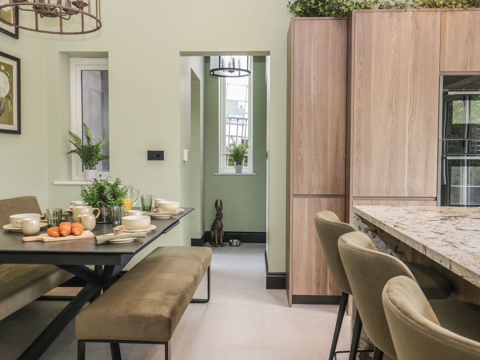 A kitchen with a dining area and wall cabinets at Low House Cottage Ayside near Newby Bridge