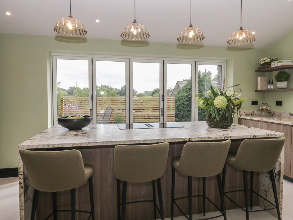A kitchen with a counter and bar stools at Low House Cottage Ayside near Newby Bridge