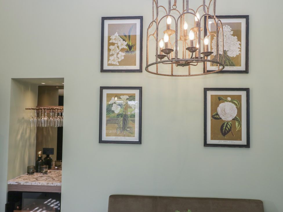 A living room with a chandelier and framed artwork at Low House Cottage Ayside near Newby Bridge