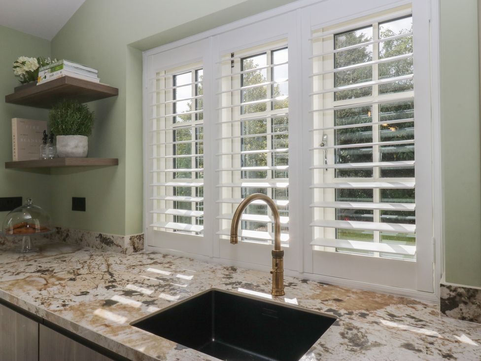 A kitchen with a sink and window at Low House Cottage Ayside near Newby Bridge