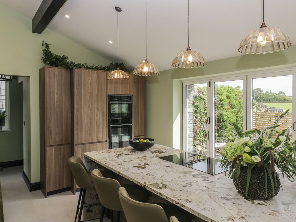 A kitchen with an island and bar stools at Low House Cottage Ayside near Newby Bridge