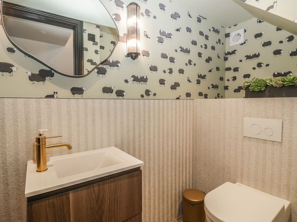 A bathroom with a sink, toilet, and mirror at Low House Cottage Ayside near Newby Bridge