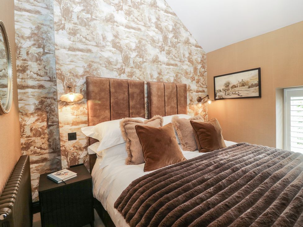 A bedroom with a bed and bedside table at Low House Cottage Ayside near Newby Bridge