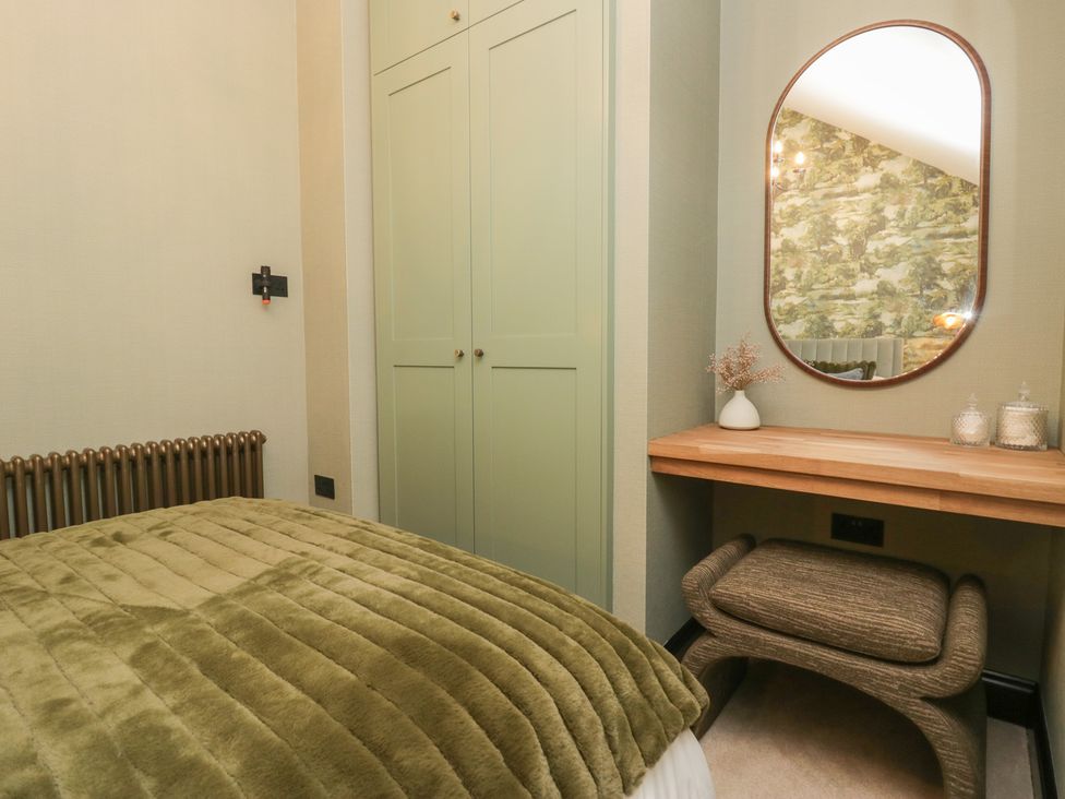 A bedroom with a bed and a mirror at Low House Cottage Ayside near Newby Bridge