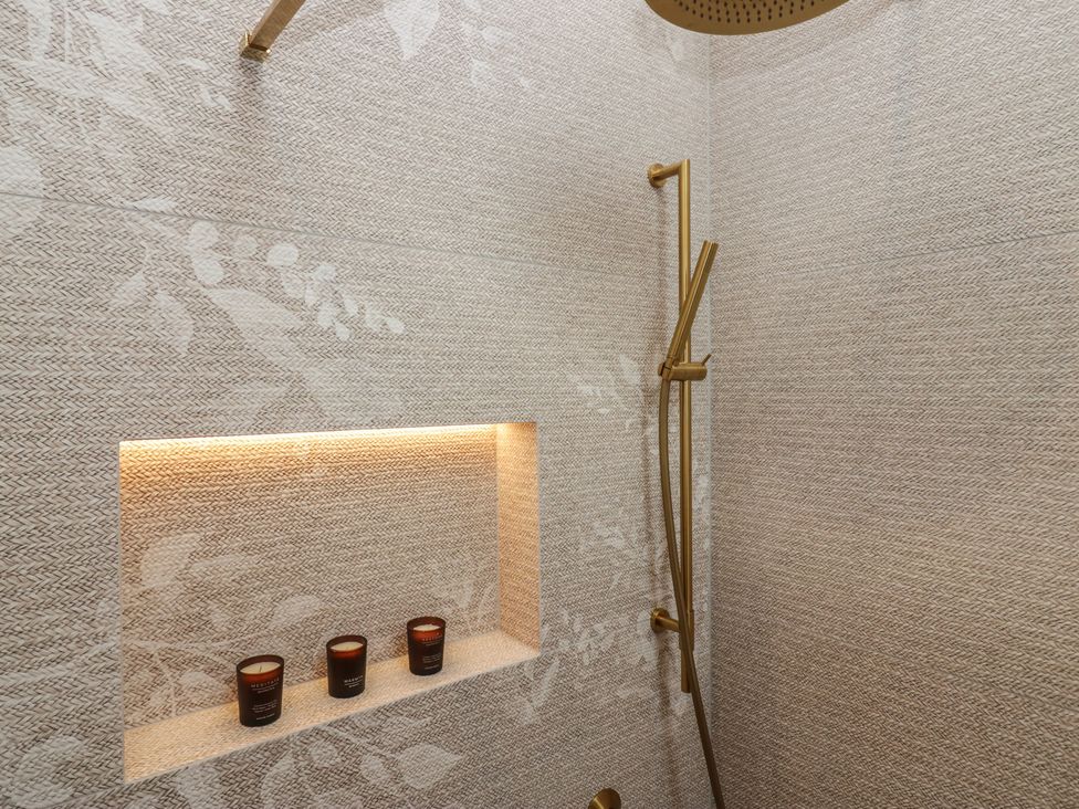 A shower area with candles in a niche at Low House Cottage Ayside near Newby Bridge