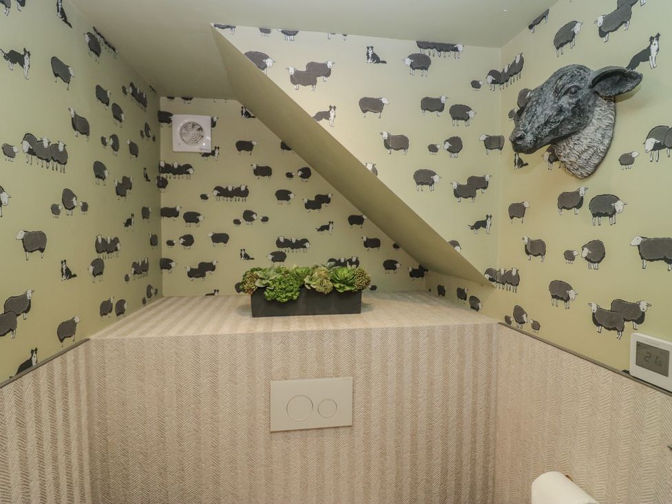 A bathroom with sheep wallpaper and a plant decoration at Low House Cottage Ayside near Newby Bridge