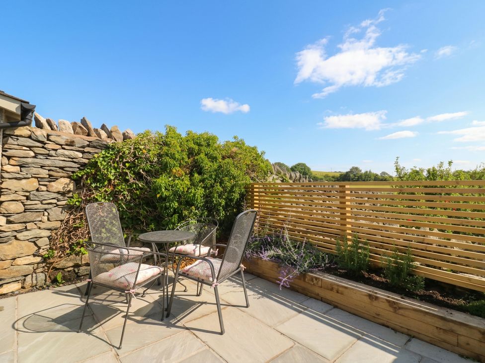 An outdoor seating area with table and chairs at Low House Cottage Ayside near Newby Bridge