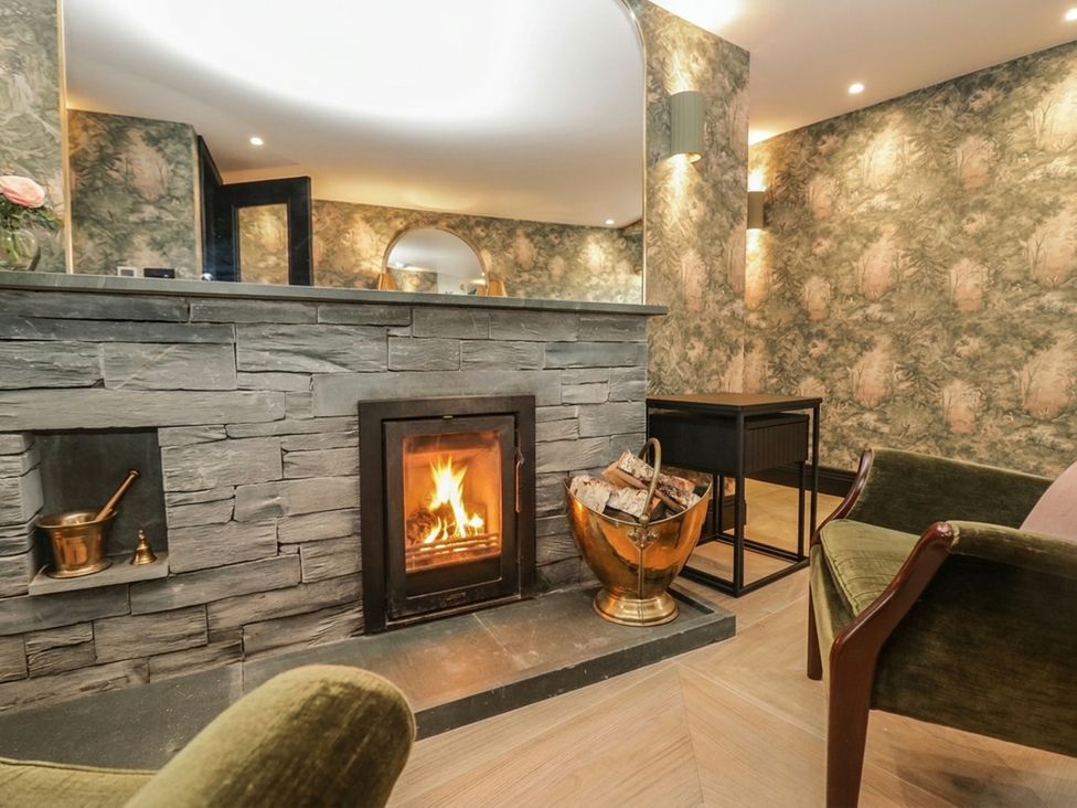 A living room with a fireplace and seating area at Low House Cottage Ayside near Newby Bridge
