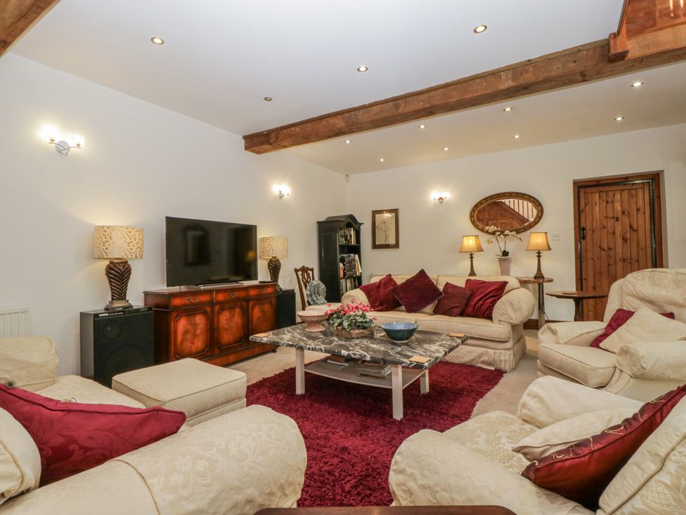 A living room with a television and sofa at The Wren's Nest in Ross-on-Wye