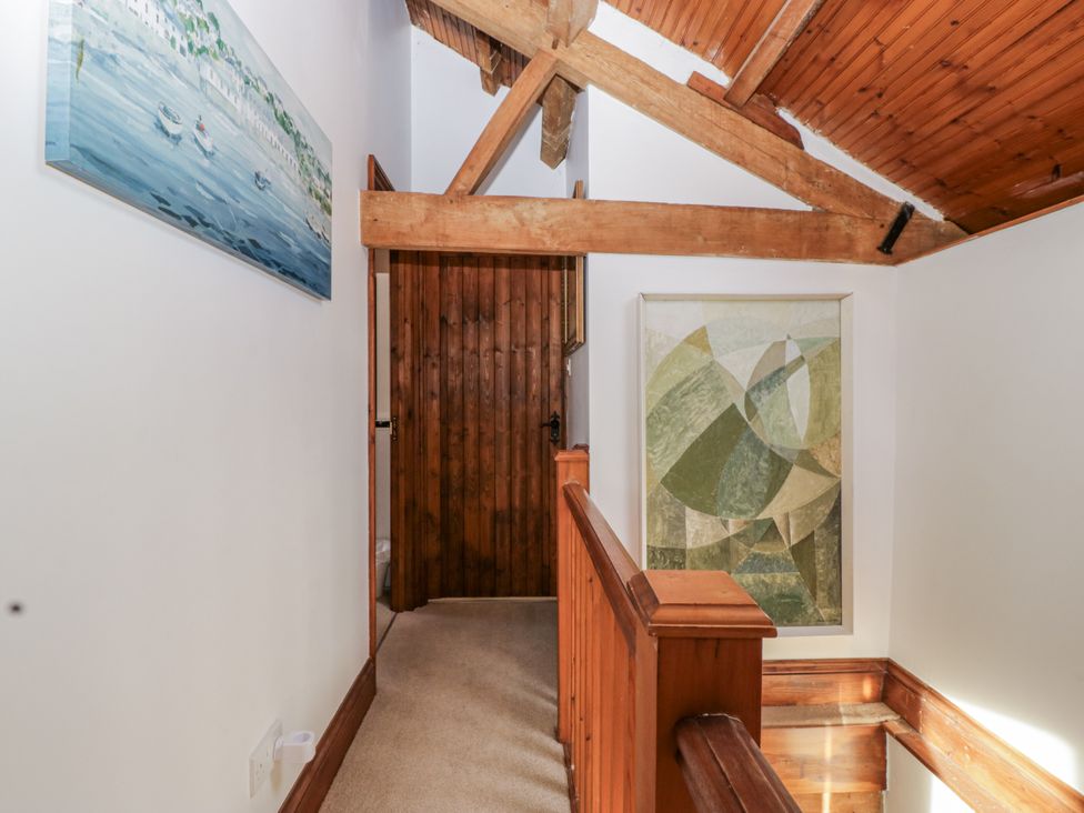 A hallway with a painting and wooden door at The Wren's Nest in Ross-on-Wye