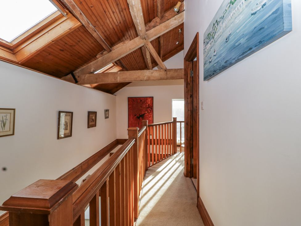 A hallway with wooden beams and artwork at The Wren's Nest in Ross-on-Wye