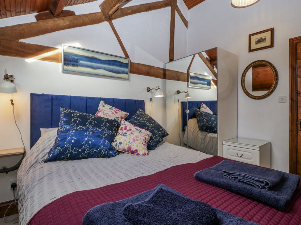 A bedroom with a bed and pillows at The Wren's Nest in Ross-on-Wye