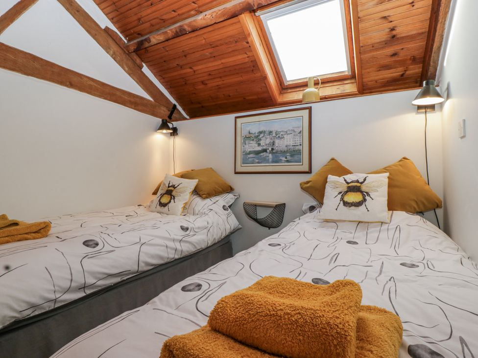 A bedroom with two beds and a window at The Wren's Nest in Ross-on-Wye