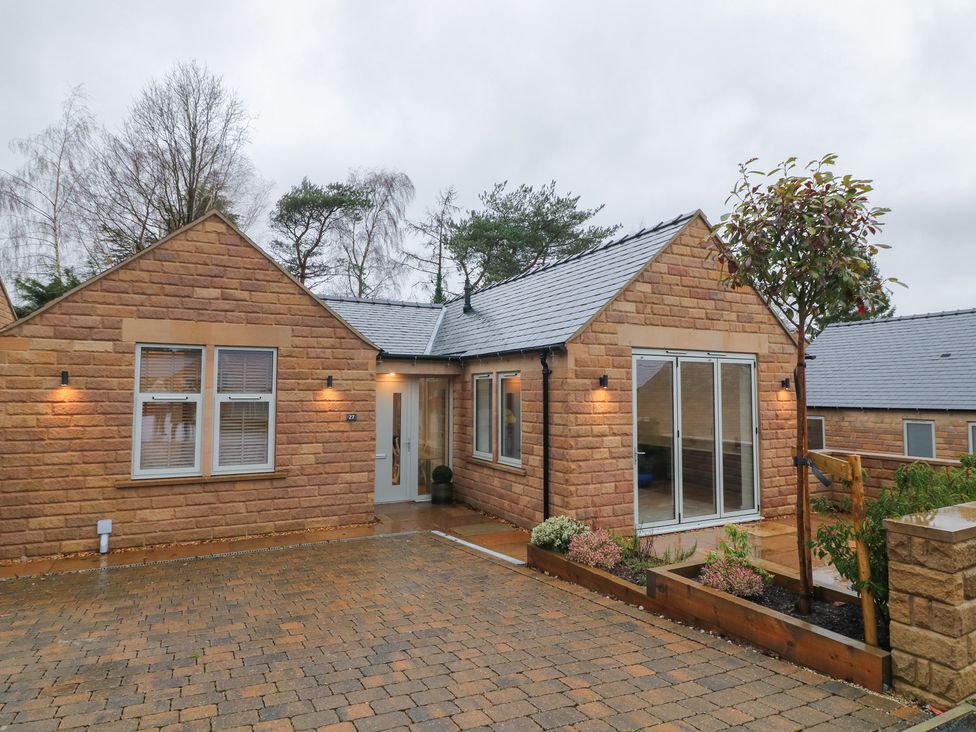 A house with a driveway and garden at Oakwood Mews in Matlock