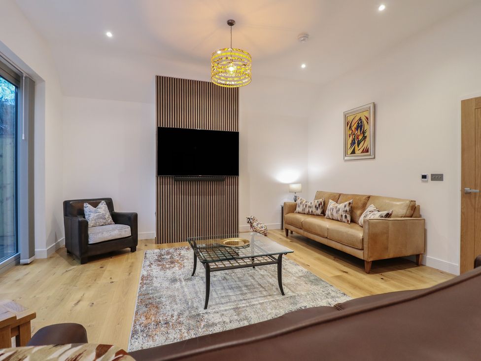 A living room with a sofa and armchair at Oakwood Mews in Matlock