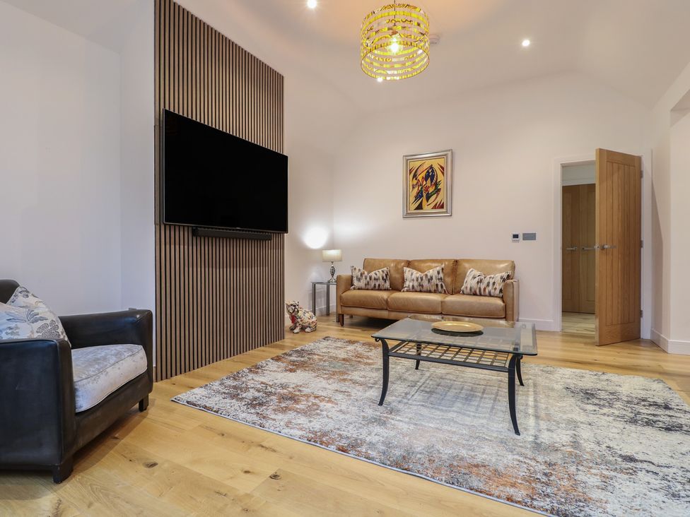 A living room with a sofa and television at Oakwood Mews in Matlock