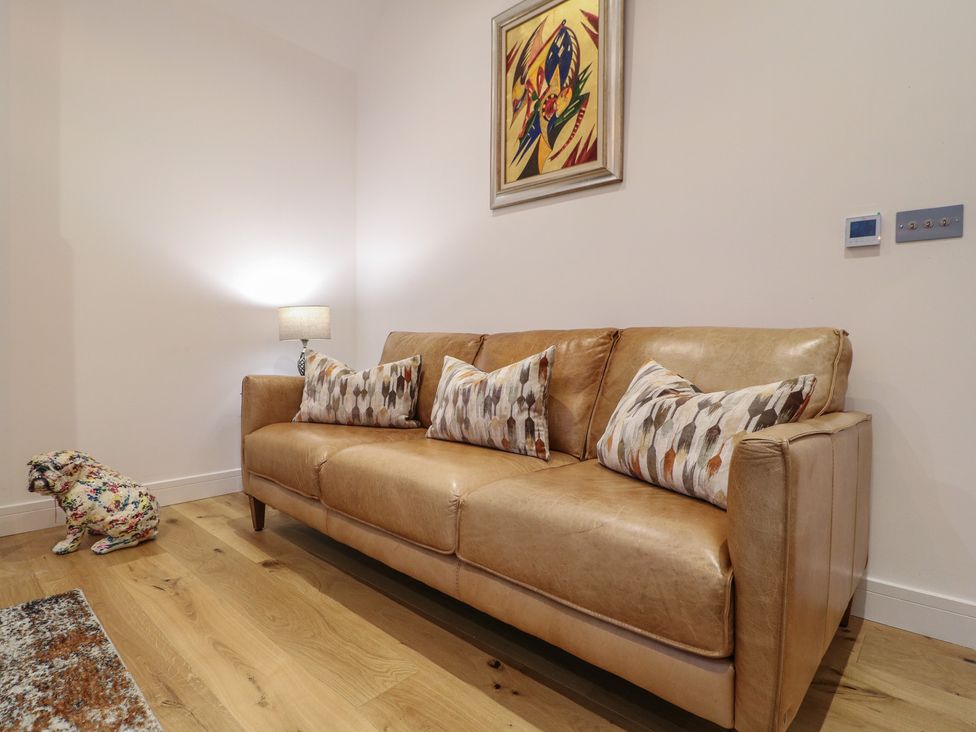 A living room with a sofa and a painting at Oakwood Mews Matlock