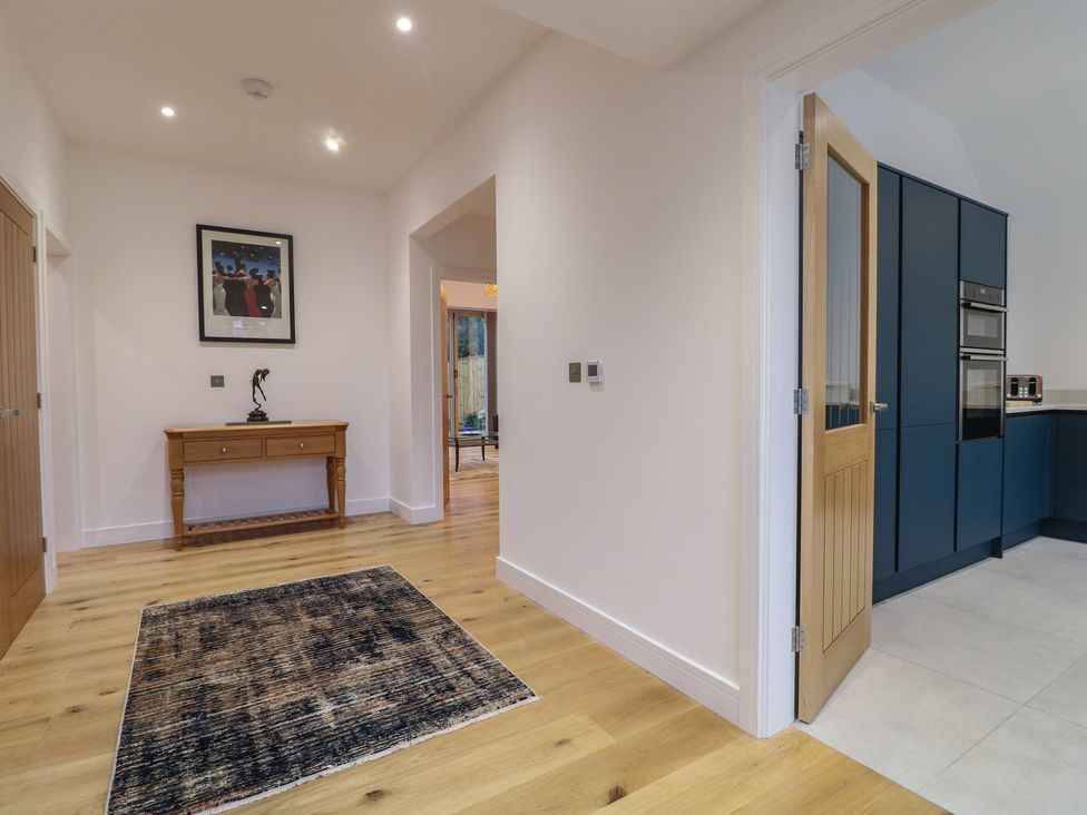 A hallway with a console table and painting at Oakwood Mews in Matlock