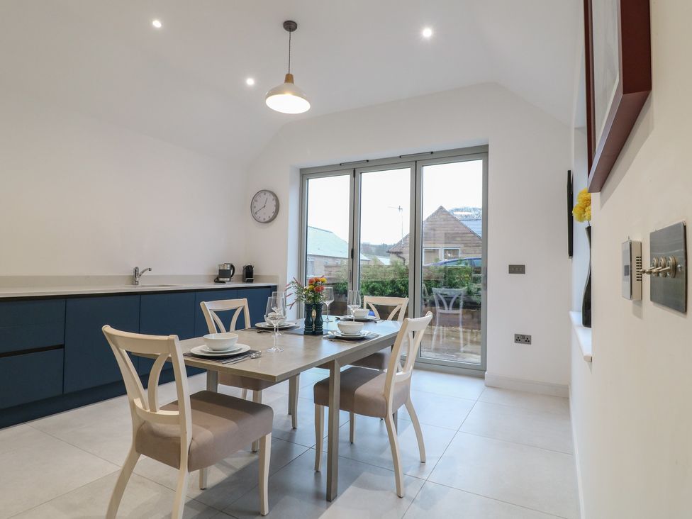 A kitchen with a dining table and chairs at Oakwood Mews in Matlock