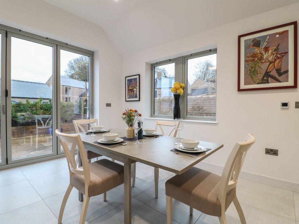 A dining room with a table set for meals at Oakwood Mews in Matlock
