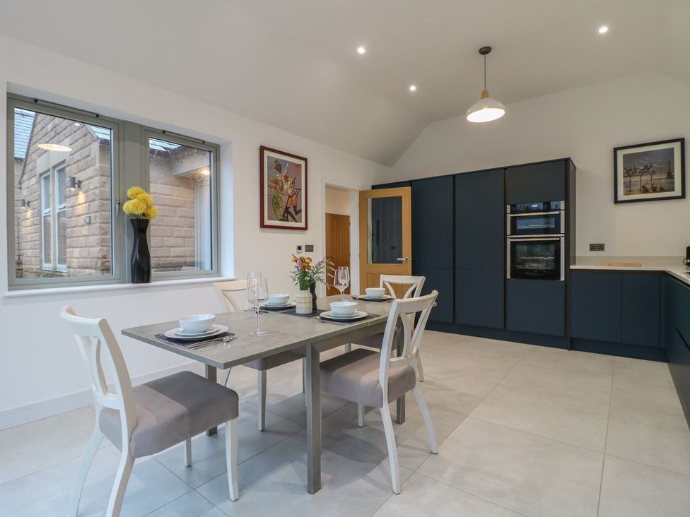 A kitchen with a dining table and chairs at Oakwood Mews in Matlock