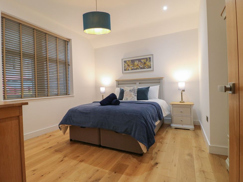 A bedroom with a bed and bedside table at Oakwood Mews in Matlock