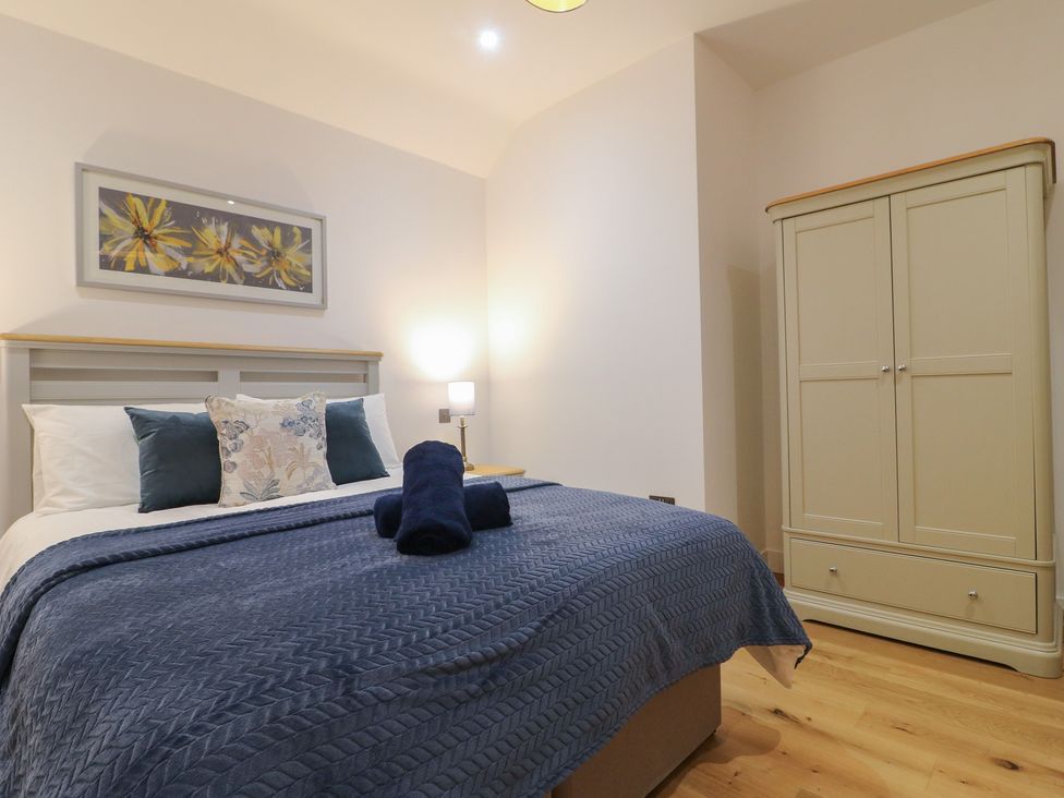 A bedroom with a bed and wardrobe at Oakwood Mews in Matlock