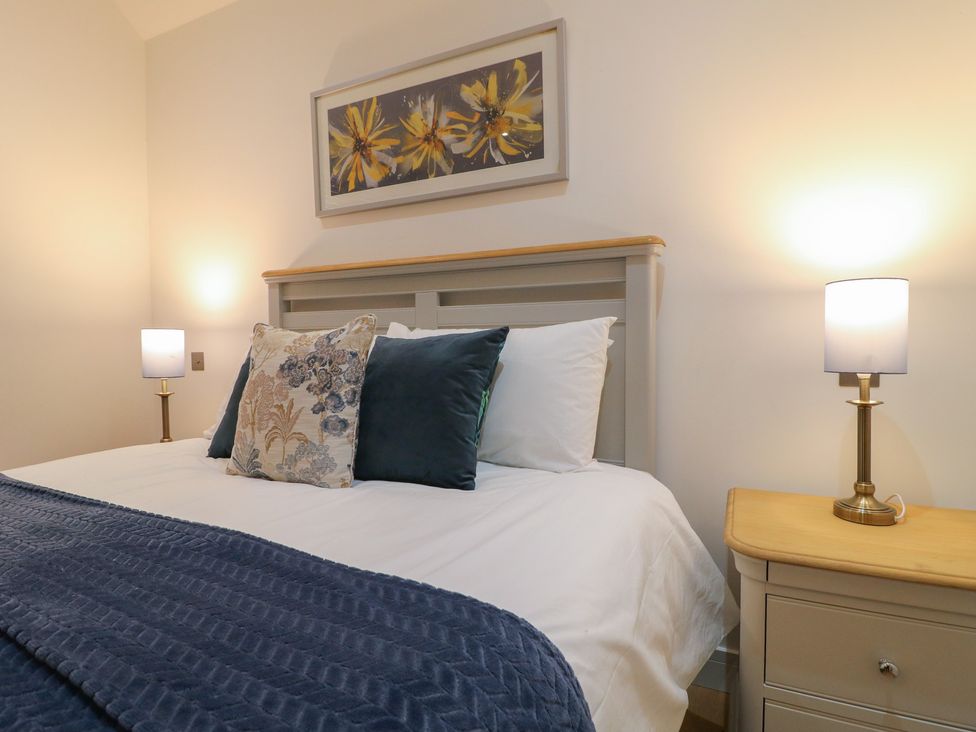 A bedroom with a bed and bedside lamps at Oakwood Mews Matlock
