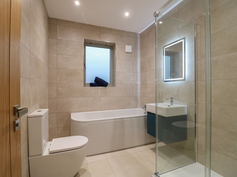 A bathroom with a shower and bathtub at Oakwood Mews in Matlock