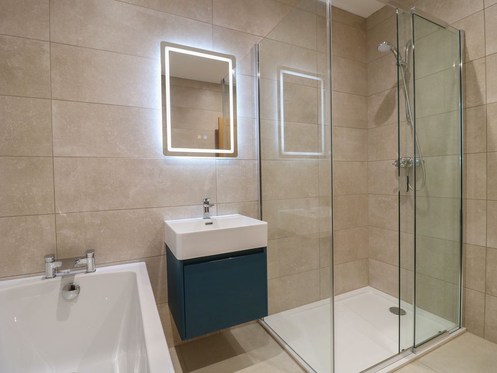 A bathroom with a sink, shower, and bath tub at Oakwood Mews in Matlock