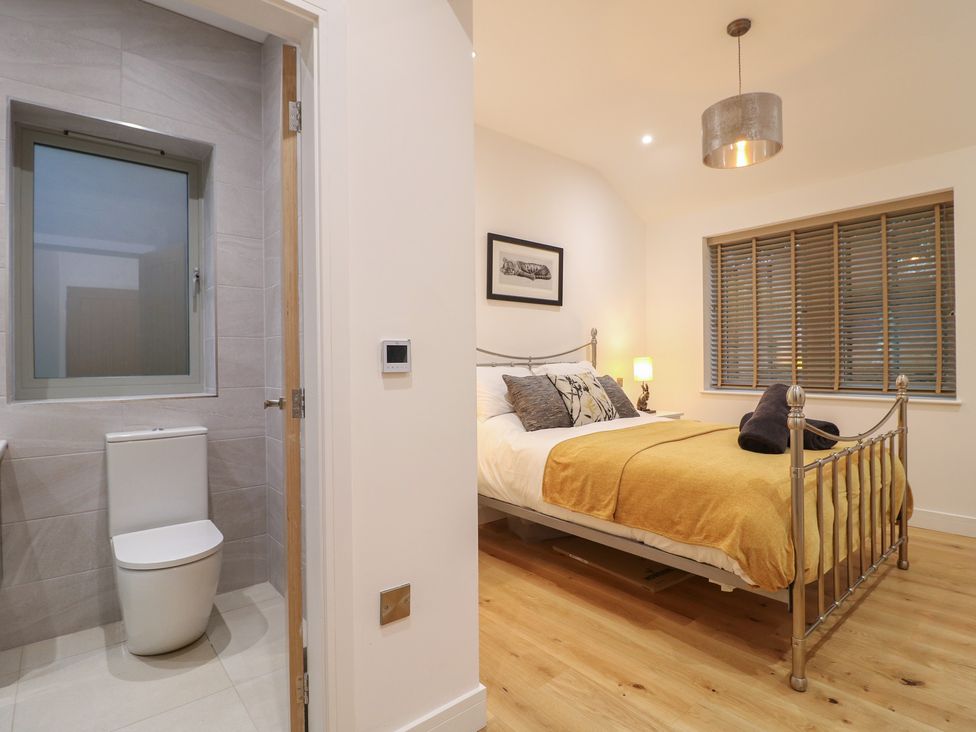 A bedroom with a bed and a bathroom area at Oakwood Mews in Matlock