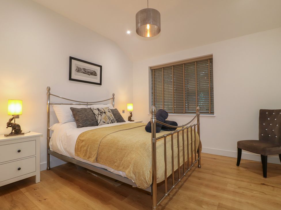A bedroom with a bed and nightstand at Oakwood Mews in Matlock