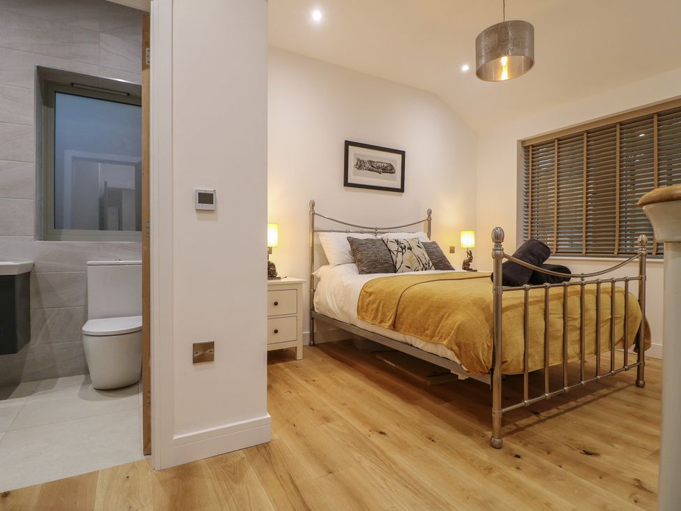 A bedroom with a bed and a bathroom visible at Oakwood Mews in Matlock