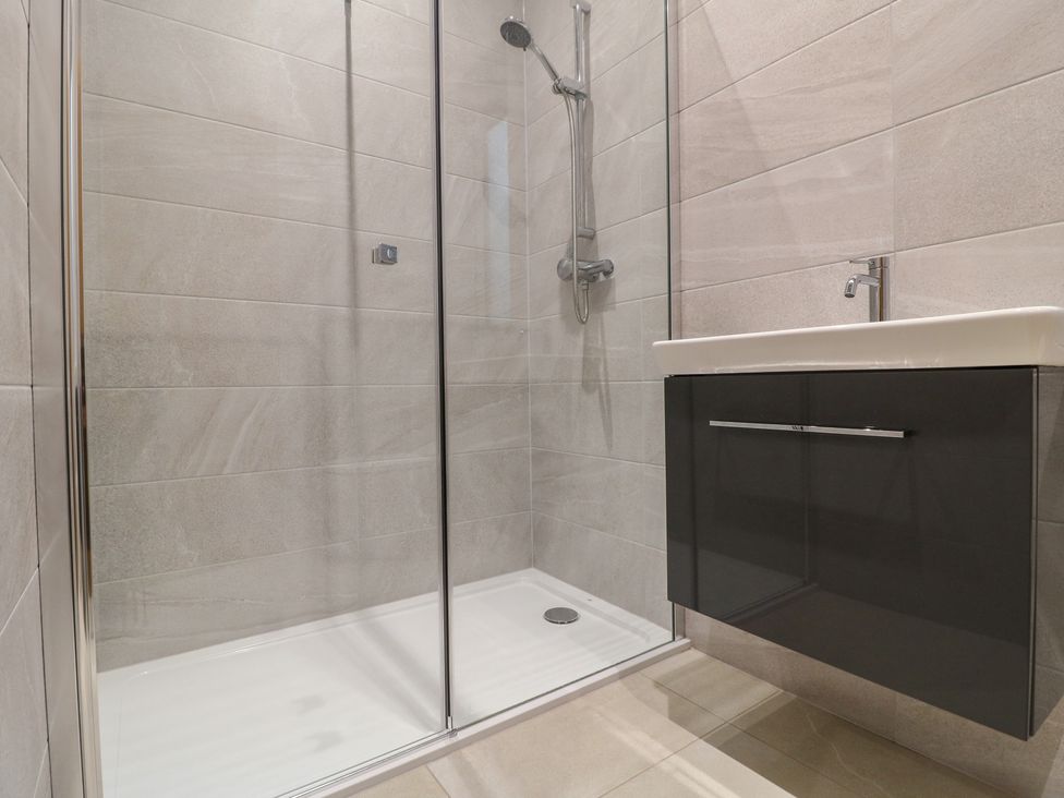 A bathroom with a shower and vanity unit at Oakwood Mews in Matlock