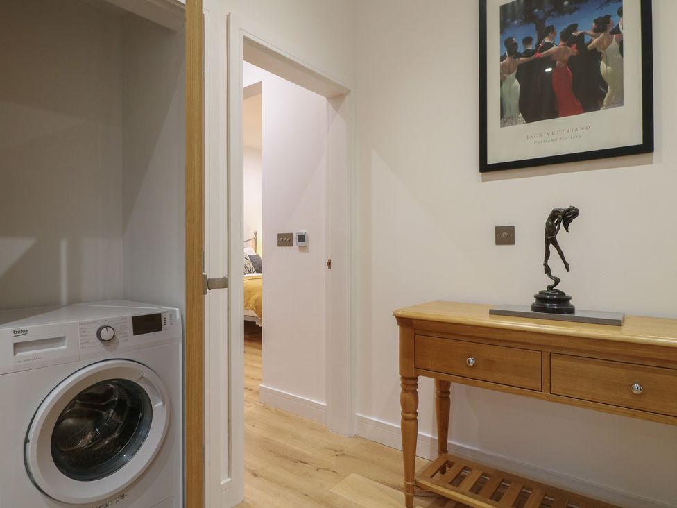 A utility room with a washing machine and a console table at Oakwood Mews in Matlock