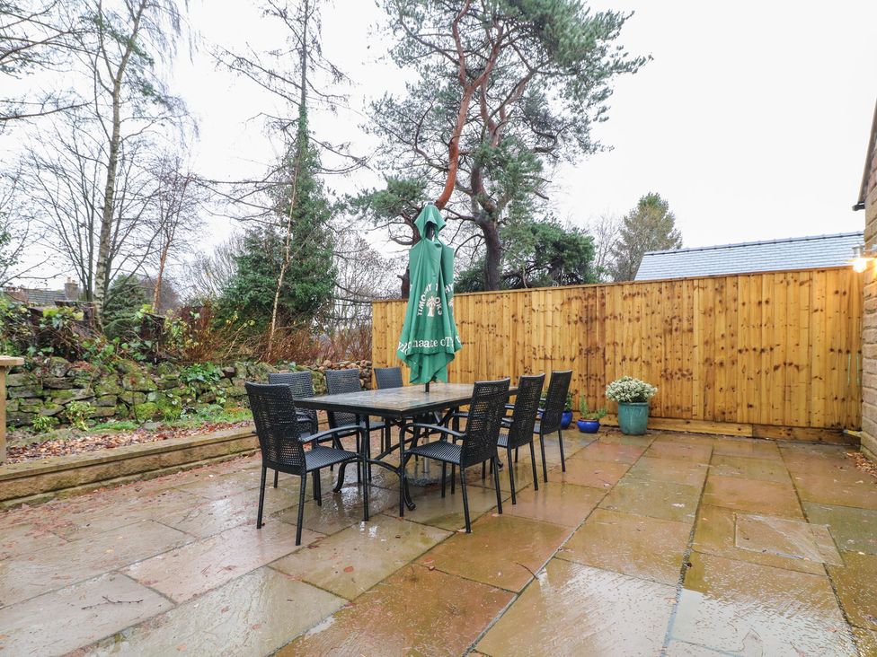 An outdoor seating area with a table and chairs at Oakwood Mews Matlock