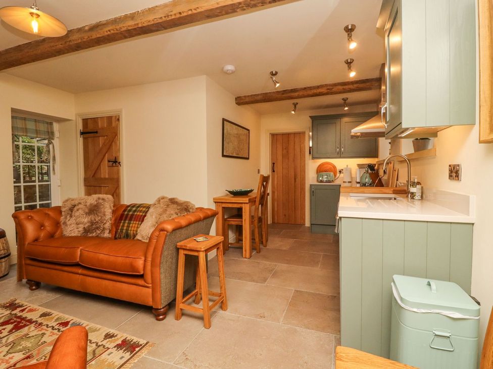 A kitchen with a sofa and dining area at Bridge House Cottage Burn Bridge near Harrogate
