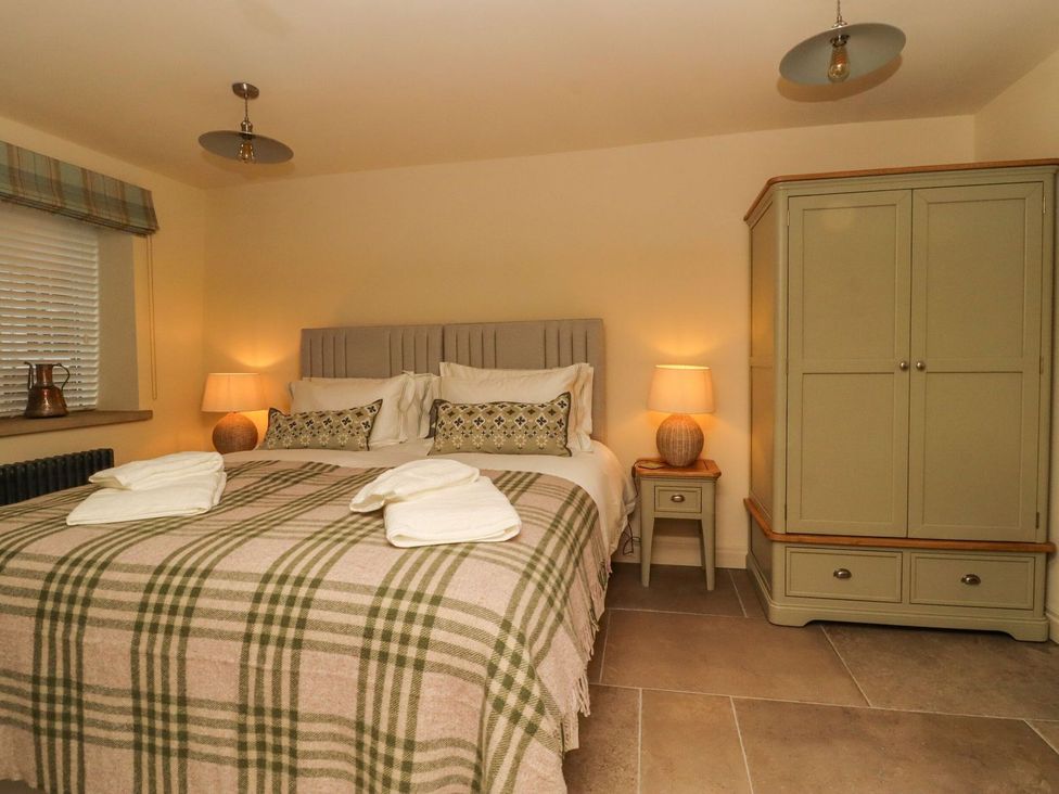 A bedroom with a bed and wardrobe at Bridge House Cottage Burn Bridge near Harrogate