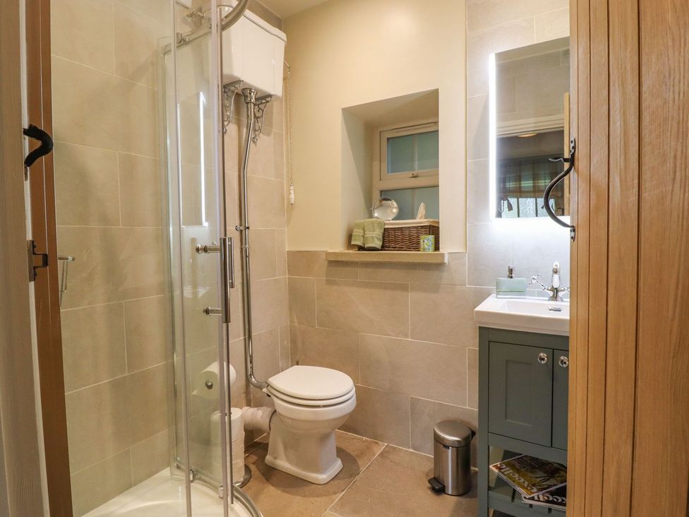A bathroom with shower, toilet, and sink at Bridge House Cottage Burn Bridge near Harrogate