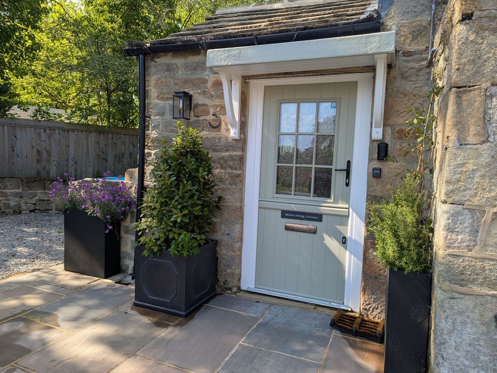 An entrance door with plant pots at Bridge House Cottage in Burn Bridge near Harrogate