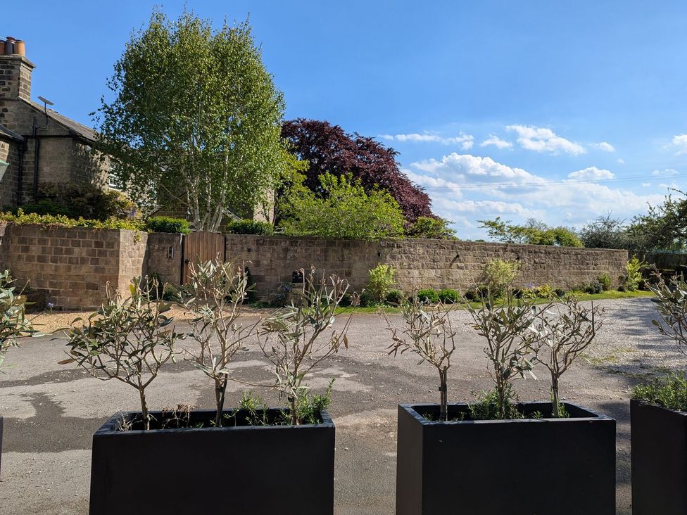 Outdoor space with planters and a wall at Bridge House Cottage in Burn Bridge near Harrogate