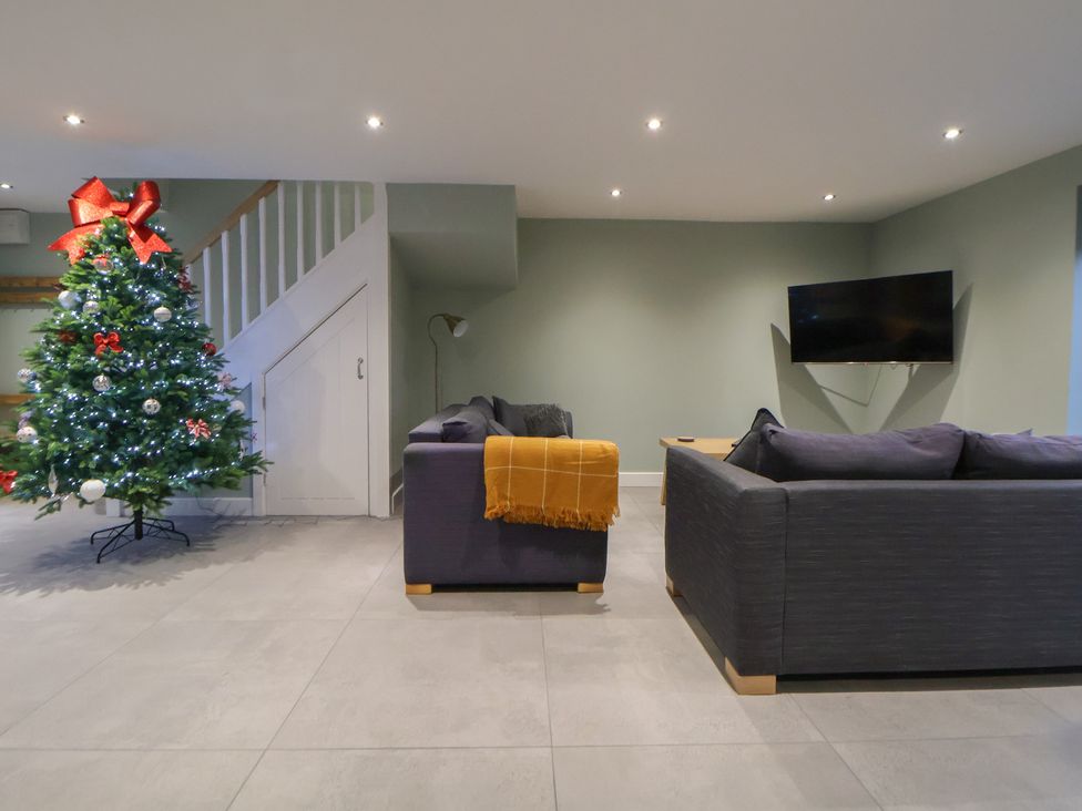 A living room with a Christmas tree and sofas at Willow Barn in Chester