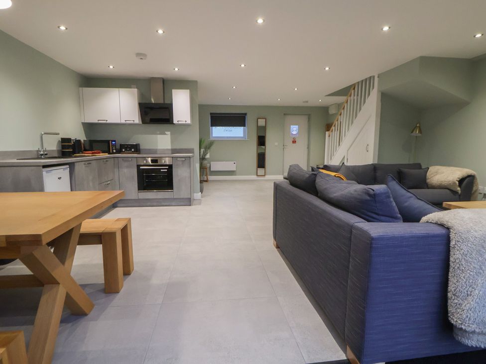 A living room with a kitchen area and dining table at Willow Barn in Chester