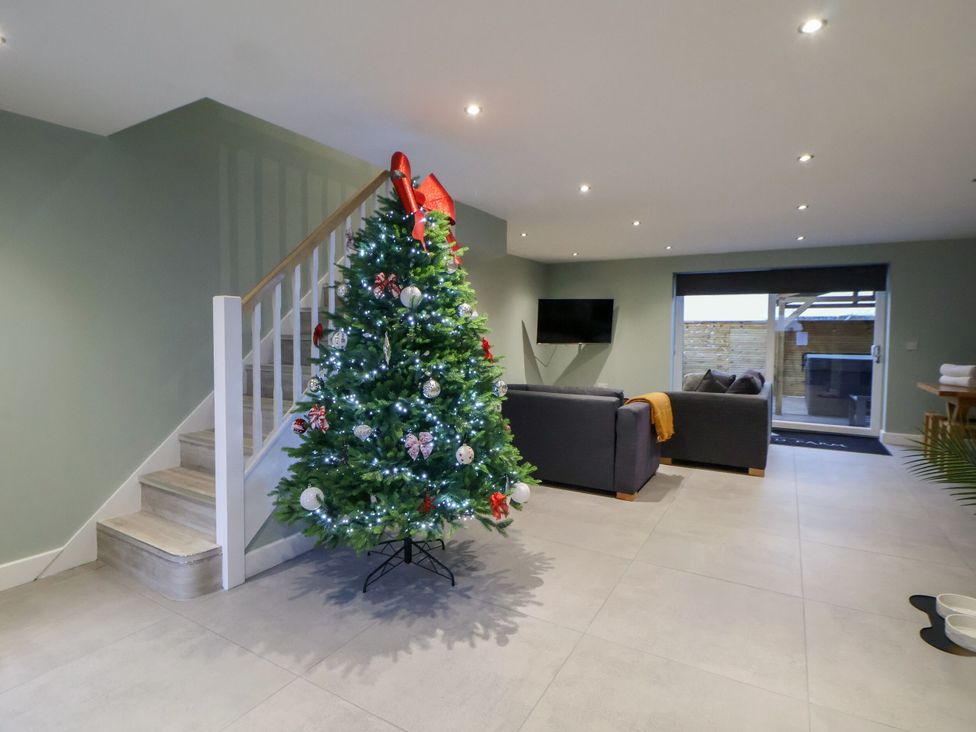 A living room with a Christmas tree and sofa at Willow Barn in Saughall
